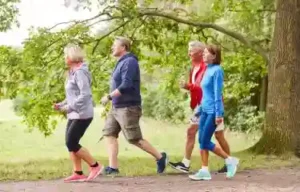 En la imagen van 4 personas caminado en un parque al aire libre