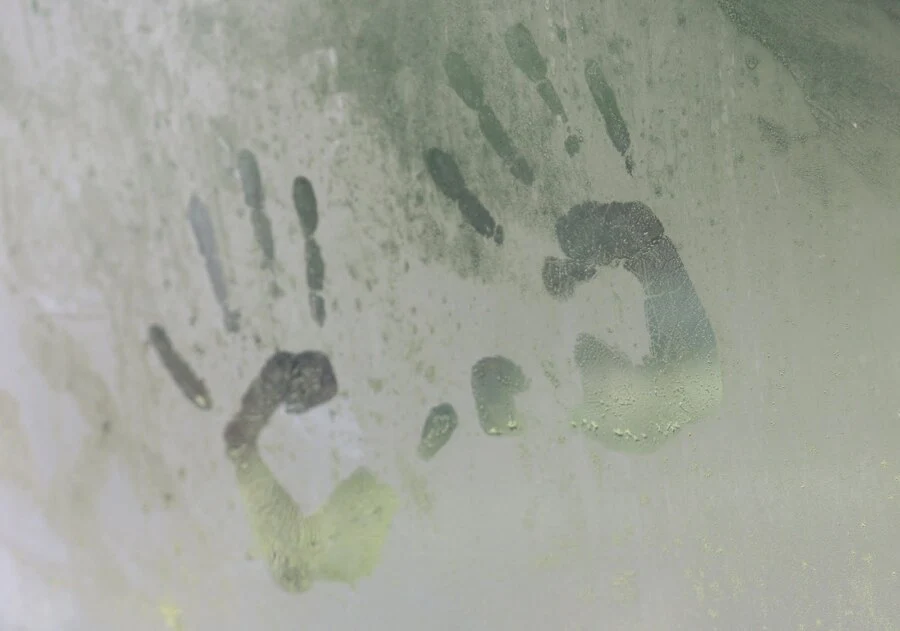 marca de manos en un vidrio, dentro de un baño de vapor